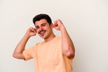 Beyaz arka planda izole genç beyaz adam özel bir günü kutluyor, atlıyor ve enerjiyle kollarını kaldırıyor..