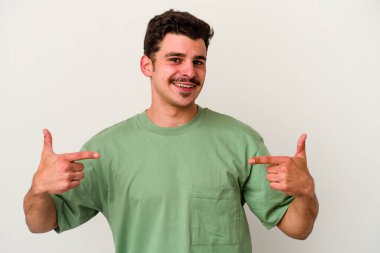 Beyaz arka planda izole edilmiş genç beyaz bir adam parmakları aşağıda, olumlu bir his var..