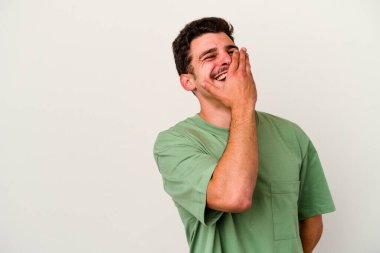 Beyaz arka planda izole olmuş genç beyaz bir adam gülüyor, kaygısız, doğal bir duygu..