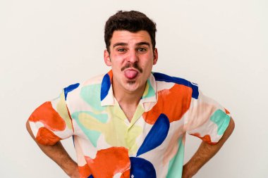 Beyaz arka planda izole edilmiş genç beyaz bir adam. Komik ve dost canlısı bir dil uzatıyor..