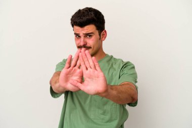 Beyaz arka planda izole edilmiş genç beyaz bir adam elini uzatmış, dur işareti göstererek seni engelliyor..