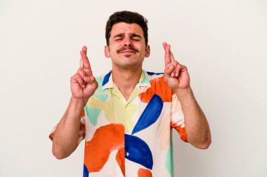 Beyaz arka planda izole genç beyaz adam şans dilemek için şans diliyor.