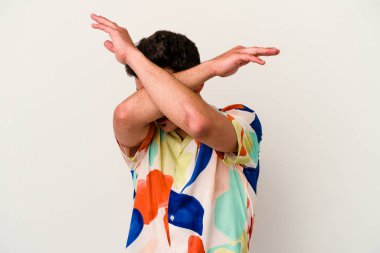 Beyaz arka planda izole genç beyaz adam iki kolu çapraz tutuyor, inkar kavramı.