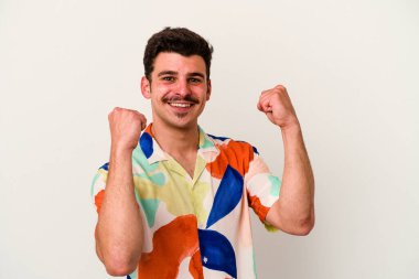 Beyaz arka planda izole edilmiş genç beyaz adam tasasız ve heyecanlı bir şekilde tezahürat yapıyor. Zafer konsepti.