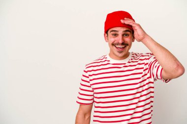 Beyaz arka planda izole genç beyaz adam yüksek sesle bağırıyor, gözleri açık ve elleri gergin tutuyor..