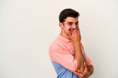 Beyaz arka planda izole olmuş genç beyaz bir adam gülüyor, kaygısız, doğal bir duygu..
