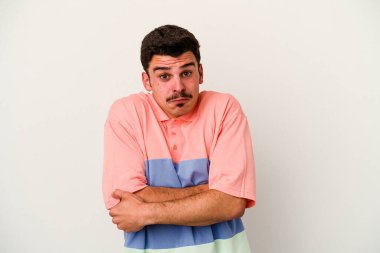 Beyaz arka planda izole edilmiş genç beyaz bir adam omuz silkiyor ve gözleri açık..