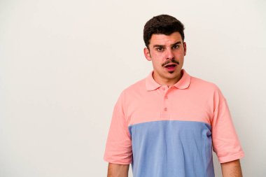 Beyaz arka planda izole edilmiş genç beyaz adam gördüğü bir şey yüzünden şoka uğruyor..