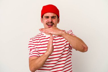 Beyaz arka planda izole edilmiş genç beyaz bir adam bir mola hareketi gösteriyor..