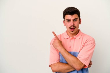 Beyaz arka planda izole edilmiş genç beyaz adam yan tarafı işaret ediyor