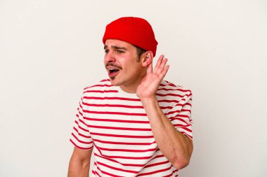 Beyaz arka planda izole edilmiş genç beyaz adam bir dedikoduyu dinlemeye çalışıyor..