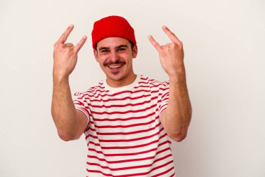 Beyaz arka planda izole edilmiş genç beyaz bir adam boynuzlarını devrim konsepti olarak gösteriyor..