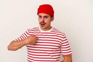 Beyaz arka planda izole edilmiş genç beyaz bir adam parmağını göstererek şaşırdı, geniş bir gülümsemeyle..