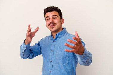 Beyaz arka planda izole edilmiş genç beyaz adam kameraya sarıldığı için kendinden emin hissediyor..