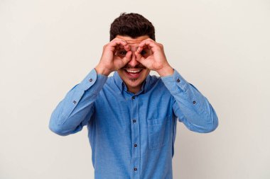 Beyaz arka planda izole edilmiş genç beyaz bir adam gözlerinde sorun olmadığını gösteriyor.