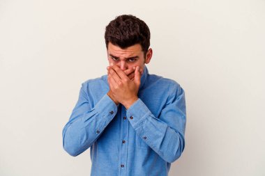 Beyaz arka planda izole edilmiş genç beyaz bir adam ağzı kapalı ve elleri endişeli görünüyor..