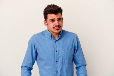 Beyaz arka planda izole edilmiş genç beyaz bir adam omuz silkiyor ve gözleri açık..