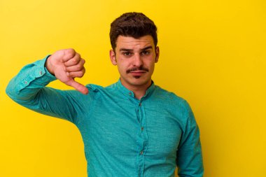 Sarı arka planda izole edilmiş, hoşlanmadığı bir hareket gösteren beyaz bir genç. Anlaşmazlık konsepti.