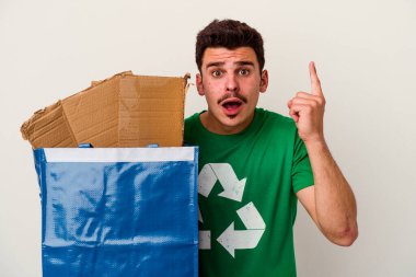 Beyaz arka planda izole edilmiş karton geri dönüşümü yapan beyaz bir adam.