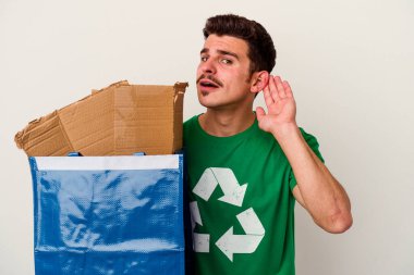 Beyaz arka planda izole edilmiş karton geri dönüşümü yapan beyaz bir adam.