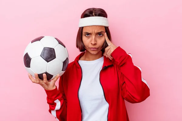 Jovem Mestiça Jogando Futebol Isolado Fundo Rosa Apontando Templo Com — Fotografia de Stock