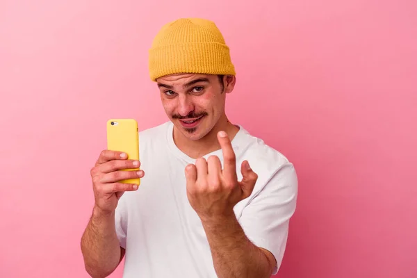Młody Biały Mężczyzna Trzyma Telefon Komórkowy Odizolowany Różowym Tle Wskazując — Zdjęcie stockowe