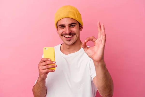 Młody Kaukaski Mężczyzna Trzymając Telefon Komórkowy Odizolowany Różowy Tło Wesoły — Zdjęcie stockowe