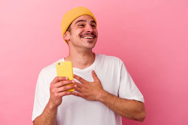 Joven Hombre Caucásico Sosteniendo Teléfono Móvil Aislado Sobre Fondo Rosa —  Fotos de Stock