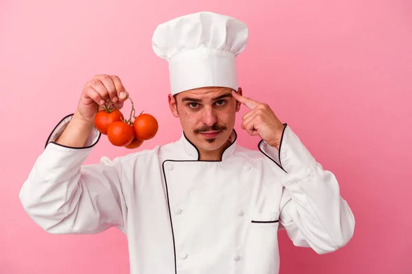 Joven Chef Caucásico Hombre Sosteniendo Tomates Aislados Sobre Fondo Rosa —  Fotos de Stock