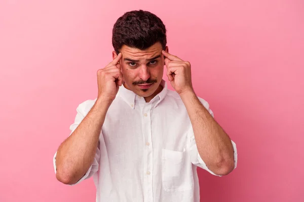 Giovane Uomo Caucasico Isolato Sfondo Rosa Focalizzato Compito Tenendo Gli — Foto Stock