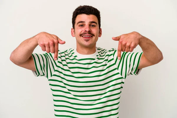 Beyaz arka planda izole edilmiş genç beyaz bir adam parmakları aşağıda, olumlu bir his var..