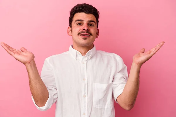 Jonge Blanke Man Geïsoleerd Roze Achtergrond Maakt Schaal Met Armen — Stockfoto