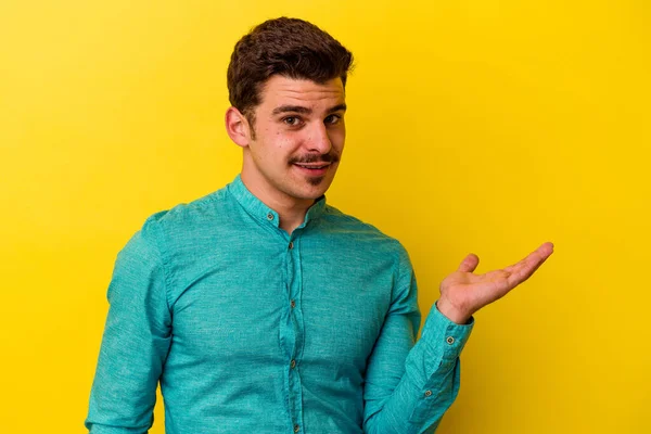 Joven Hombre Caucásico Aislado Sobre Fondo Amarillo Mostrando Espacio Copia —  Fotos de Stock