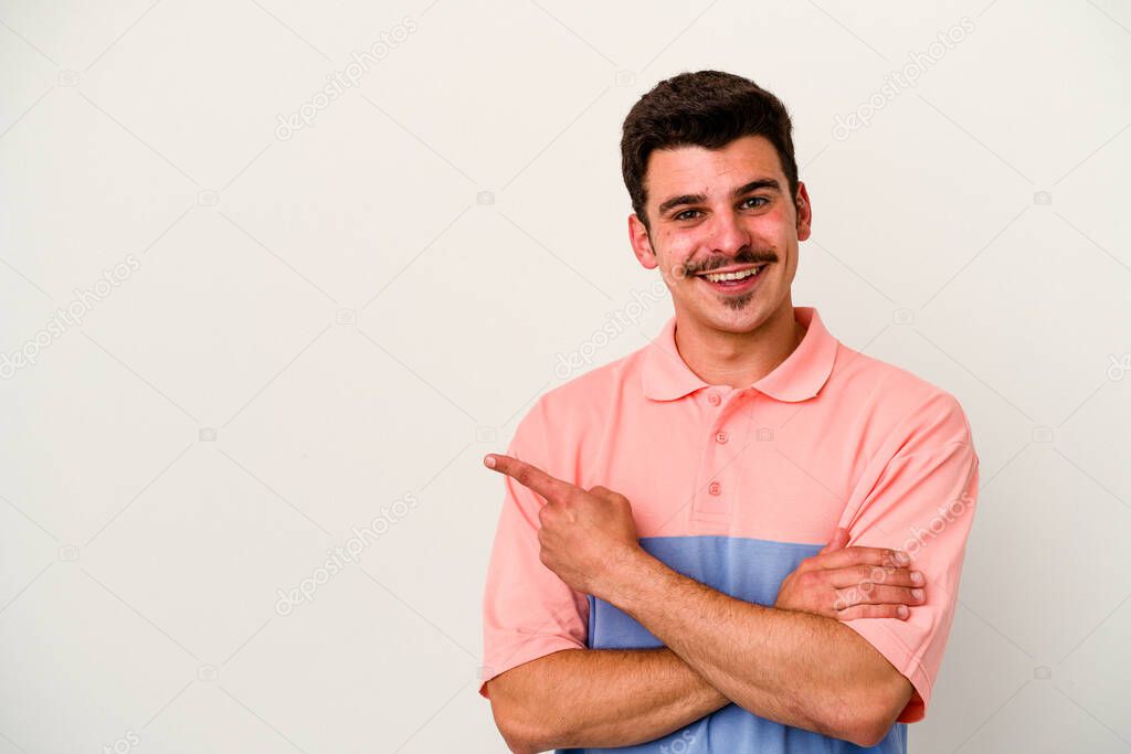 Young caucasian man isolated on white background smiling cheerfully pointing with forefinger away.