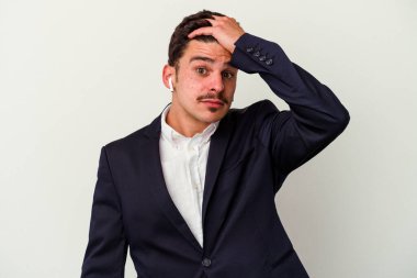 Beyaz arka planda izole edilmiş kablosuz kulaklık takan genç beyaz iş adamı şoka uğruyor..