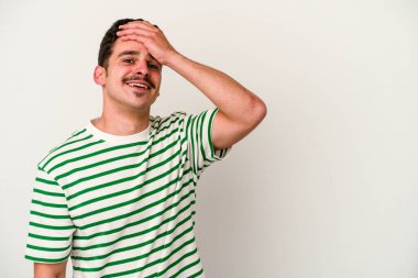 Beyaz arka planda izole olmuş genç beyaz bir adam gülüyor, kaygısız, doğal bir duygu..