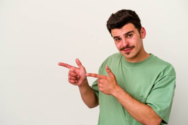 Beyaz arka planda izole edilmiş genç beyaz bir adam işaret parmağıyla fotokopi alanını işaret ederek heyecan ve arzusunu ifade ediyor..