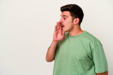 Beyaz arka planda izole edilmiş genç beyaz bir adam gizli bir sıcak fren haberi veriyor ve yana bakıyor.