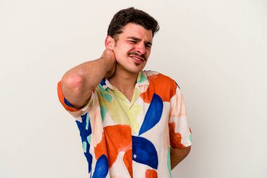 Beyaz arka planda izole edilmiş genç beyaz bir adam yorgun ve uykulu bir şekilde elini başının üstünde tutuyor..