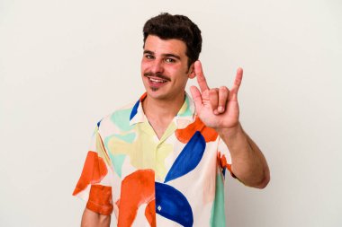 Beyaz arka planda izole edilmiş genç beyaz bir adam boynuzlarını devrim konsepti olarak gösteriyor..