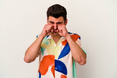 Beyaz arka planda ağlayan ve sızlanan beyaz tenli genç bir adam var..