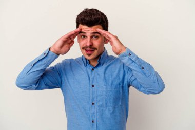 Beyaz arka planda izole genç beyaz adam hoş bir sürpriz alıyor, heyecanlı ve el kaldırıyor..