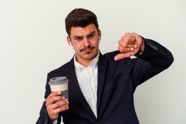 Kablosuz kulaklık takan ve elinde tuttuğu genç beyaz arka planda izole edilmiş kahve tutan beyaz iş adamı hoşnutsuz bir jest yapıyor. Anlaşmazlık konsepti.
