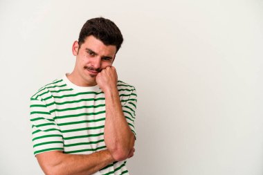 Beyaz arka planda izole edilmiş, üzgün ve dalgın hisseden genç beyaz bir adam fotokopi alanına bakıyor..