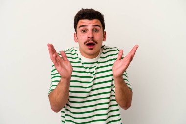 Beyaz arka planda izole edilmiş genç beyaz adam şaşırdı ve şok oldu..