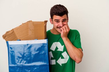 Beyaz arka planda izole edilmiş karton geri dönüşümü yapan beyaz bir adam.