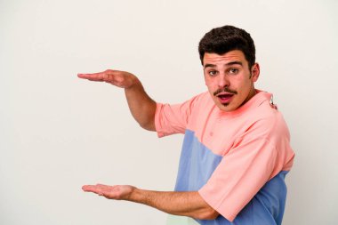 Beyaz arka planda izole edilmiş genç beyaz adam elleri arasında bir kopya alanı tutarken şok ve hayrete düştü..