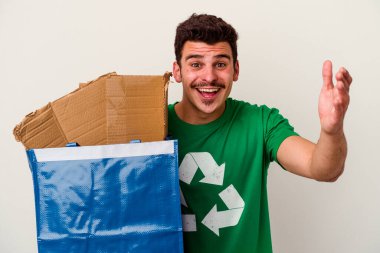 Beyaz arka planda izole edilmiş karton geri dönüşümü yapan beyaz bir adam.