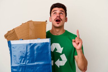 Beyaz arka planda izole edilmiş karton geri dönüşümü yapan beyaz bir adam.