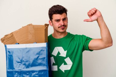 Beyaz arka planda izole edilmiş karton geri dönüşümü yapan beyaz bir adam.